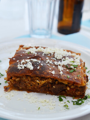 Discover the delectable flavours of Kefalonia with the renowned Kefalonian Meat Pie. This traditional dish features a hearty filling of ground meat, often a combination of beef and pork, cooked with onions, garlic, herbs, and spices. Encased in a flaky pastry crust, the savoury pie is baked to golden perfection. Each bite reveals a flavorful blend of meat and aromatic seasonings that showcase the island's culinary heritage. Served warm as a main course or enjoyed as a snack, the Kefalonian Meat Pie is a must-try dish that embodies the rich and savoury flavours of Kefalonia