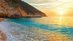 "Image: Experience the mesmerising sunsets of Kefalonia, Greece, with our comprehensive sunset guide. Discover the best spots on the island to witness breathtaking displays of colours as the sun dips below the horizon. From the romantic setting of Assos village, where the pastel hues reflect on the calm waters, to the picturesque cliffs of Skala, offering panoramic views of the Aegean Sea, Kefalonia is a haven for sunset enthusiasts. Our guide provides insights into ideal locations, timing, and photography tips to capture the magical moments as the sky transforms into a masterpiece of shades and patterns. Don't miss the opportunity to be enchanted by the captivating sunsets of Kefalonia